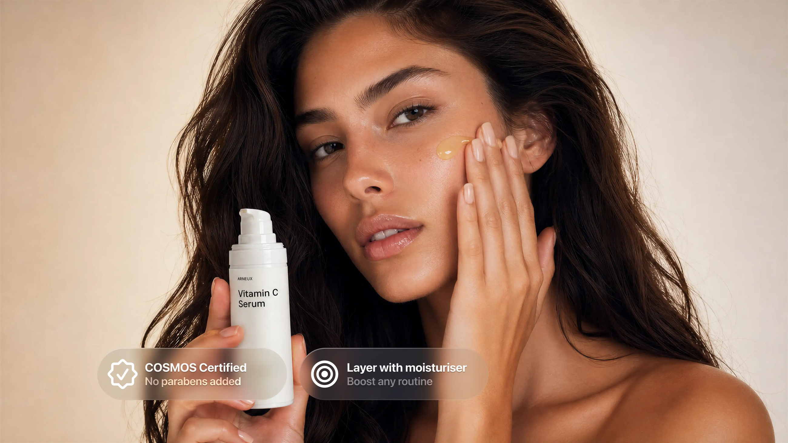 Woman applying AURA vitamin C serum to cheek, COSMOS certified layer with moisturiser callout