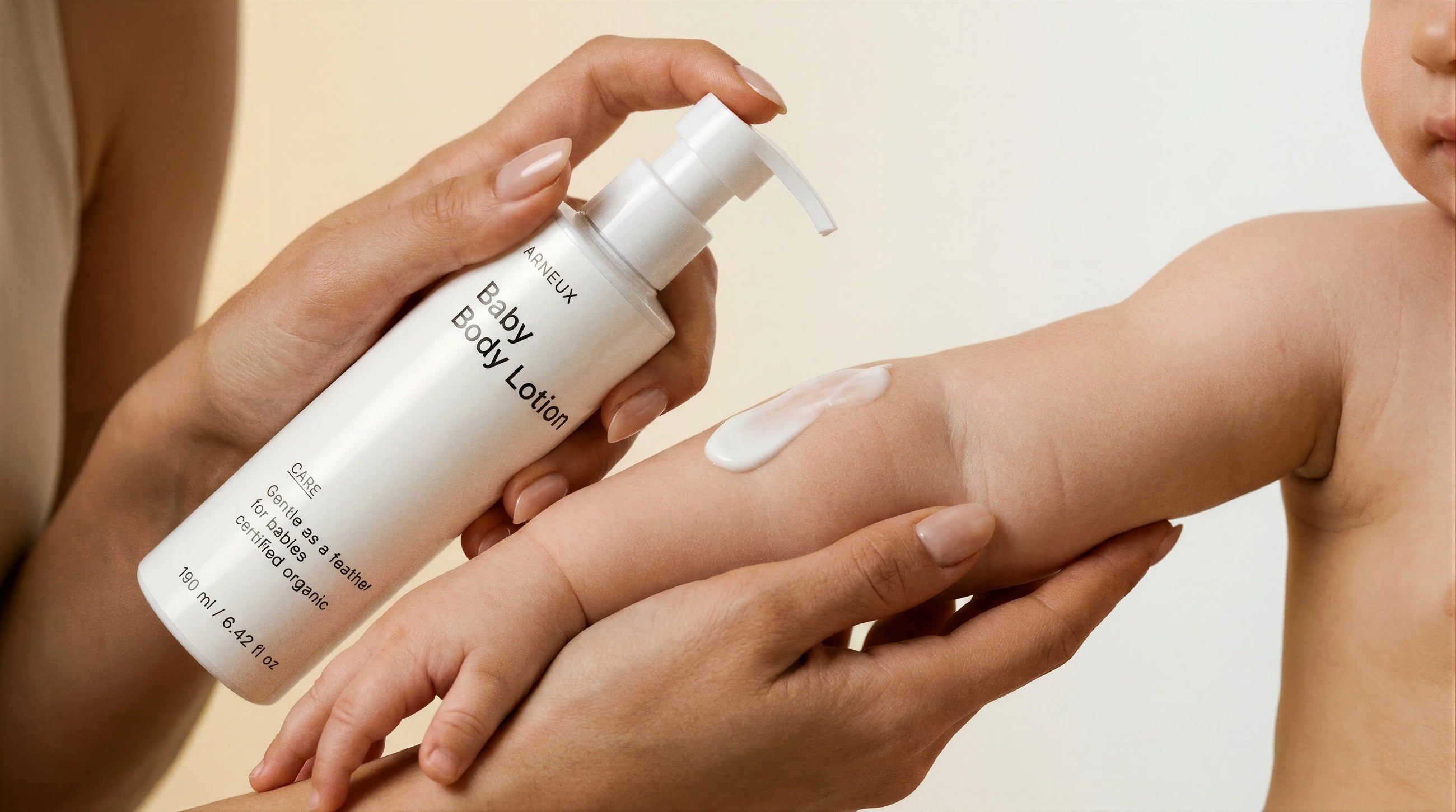 Adult hands applying CARE baby body lotion, gentle COSMOS certified formula for newborns and up