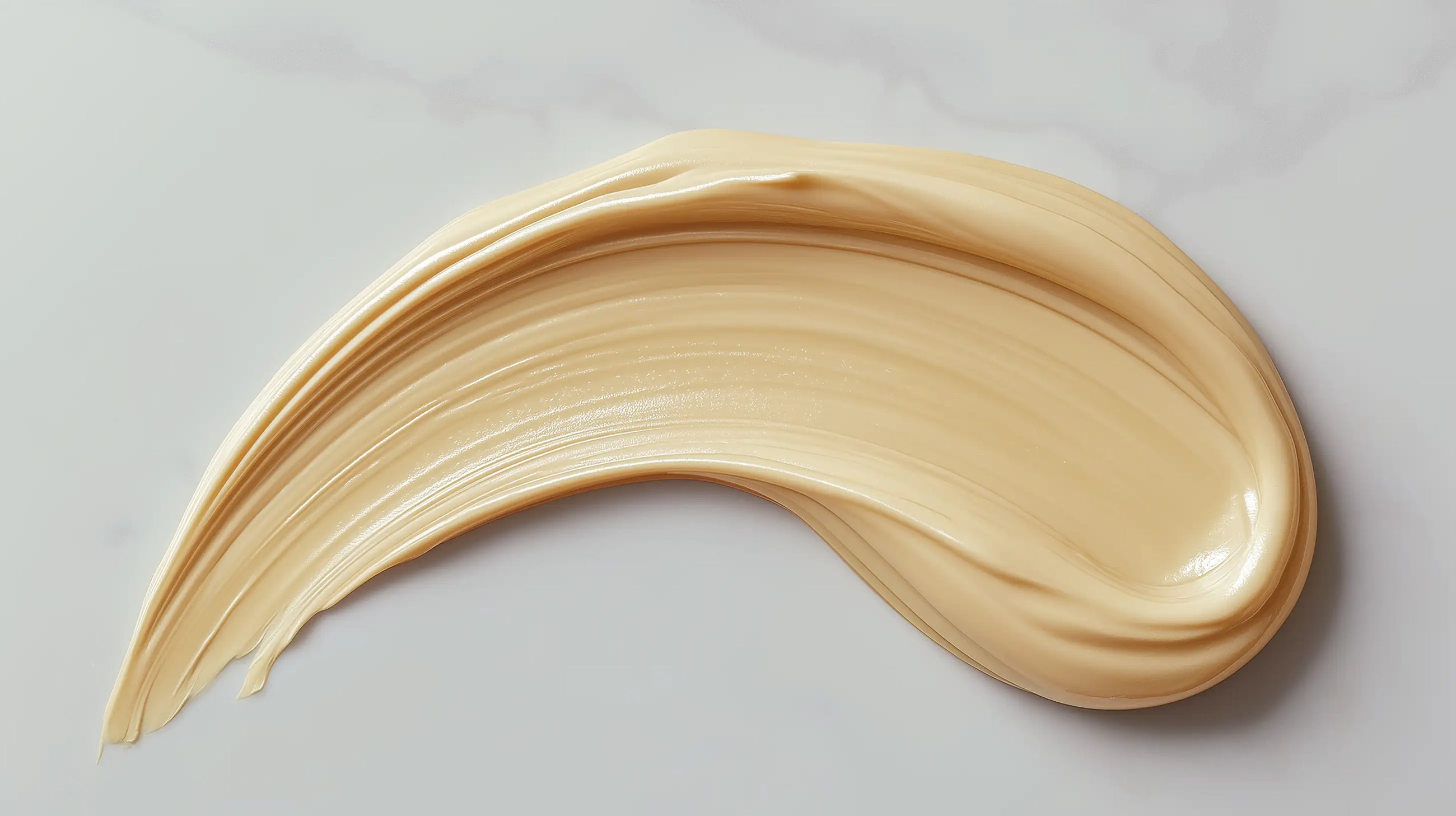 Dark spot care treatment cream beige texture swatch on warm surface, targeted formula consistency