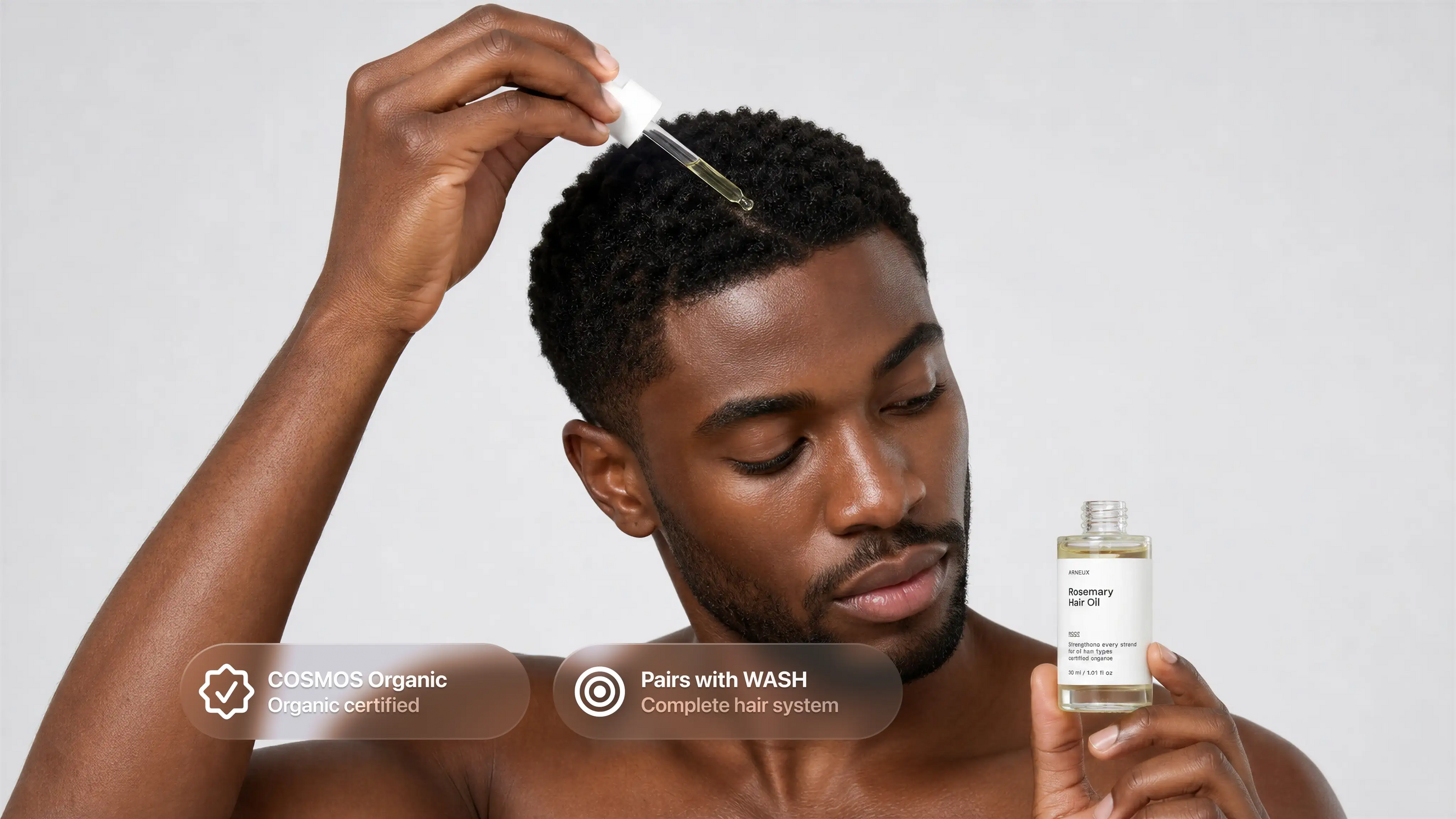 Man dropping ROOT rosemary hair oil onto scalp, COSMOS organic certified pairs with WASH callout