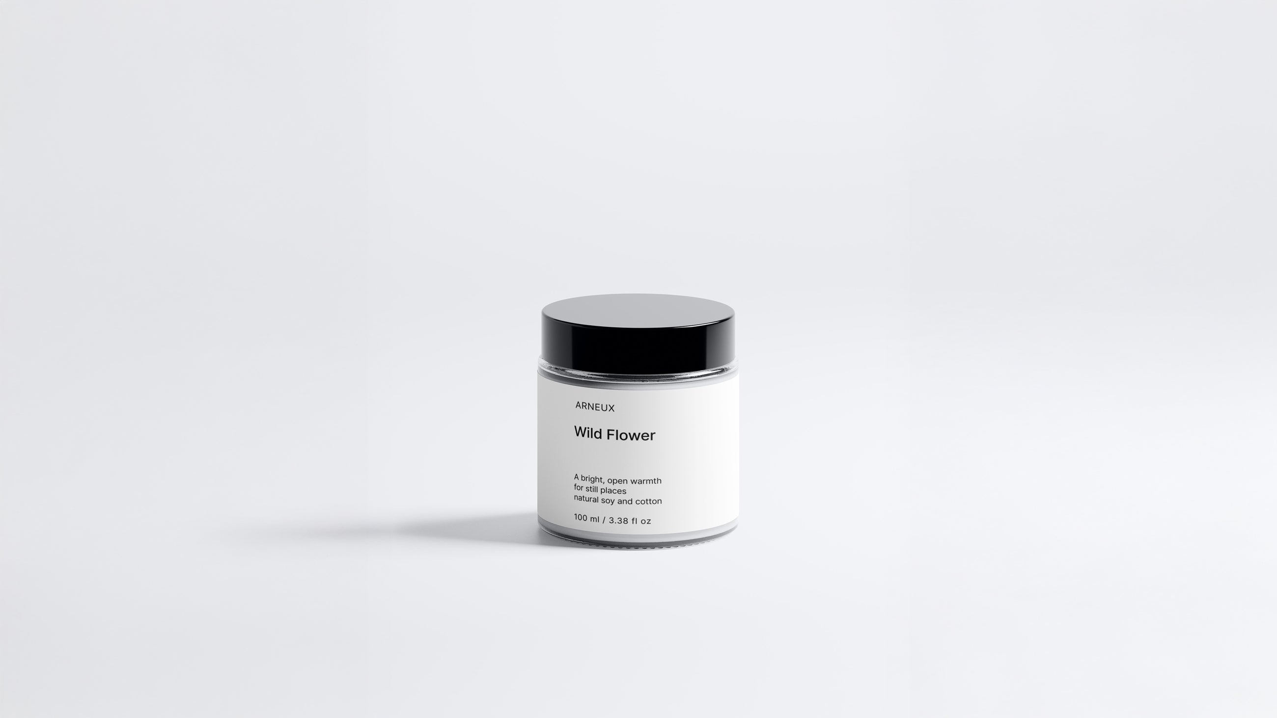 Arneux WILD FLOWER travel candle glass jar with black lid, light floral soy wax candle front view on grey background