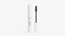 A white mascara tube labeled ARNEUX stands next to its open wand applicator with a black bristle brush, on a clean white background