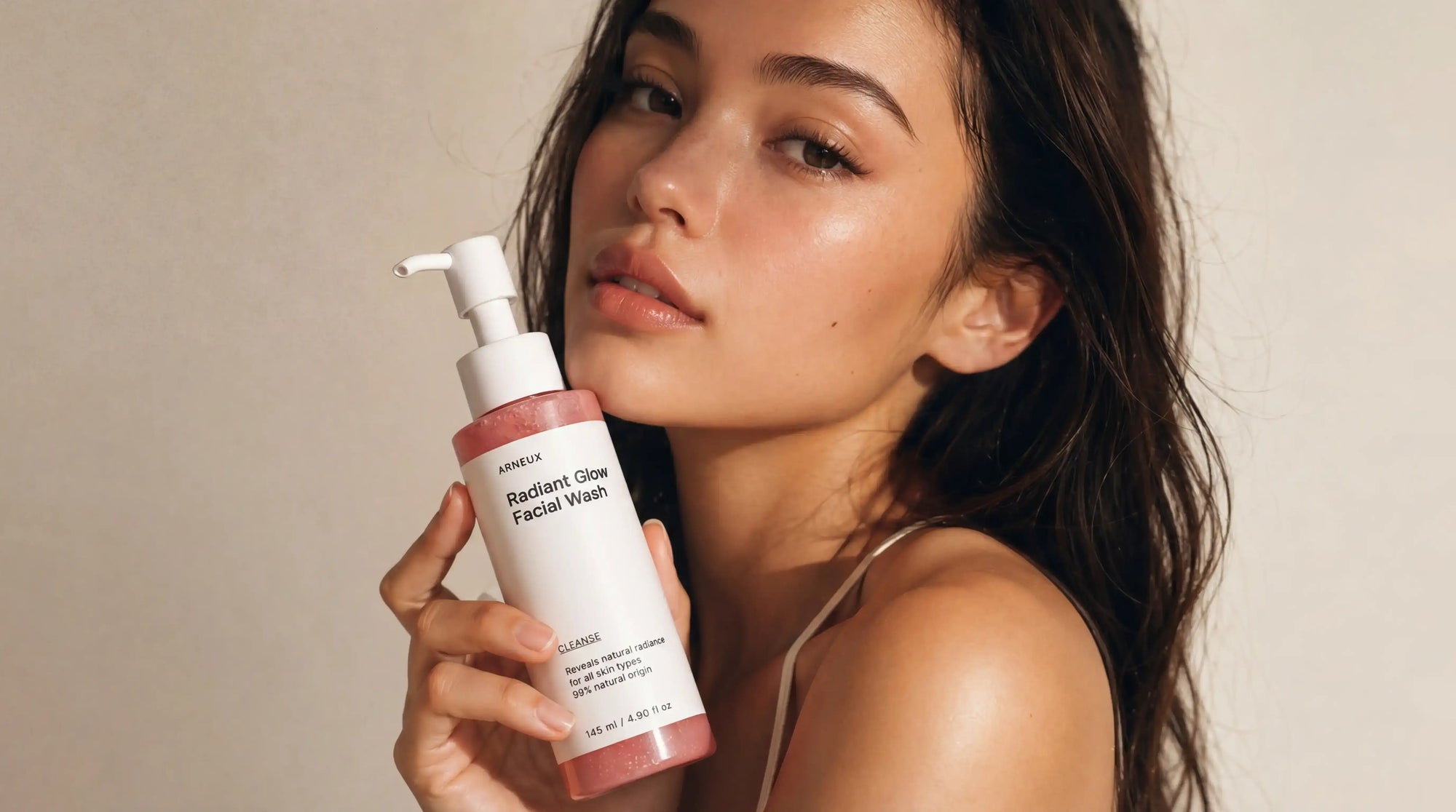 Woman holding Arneux CLEANSE Radiant Glow Facial Wash, European cosmetics standards 100% natural origin formula