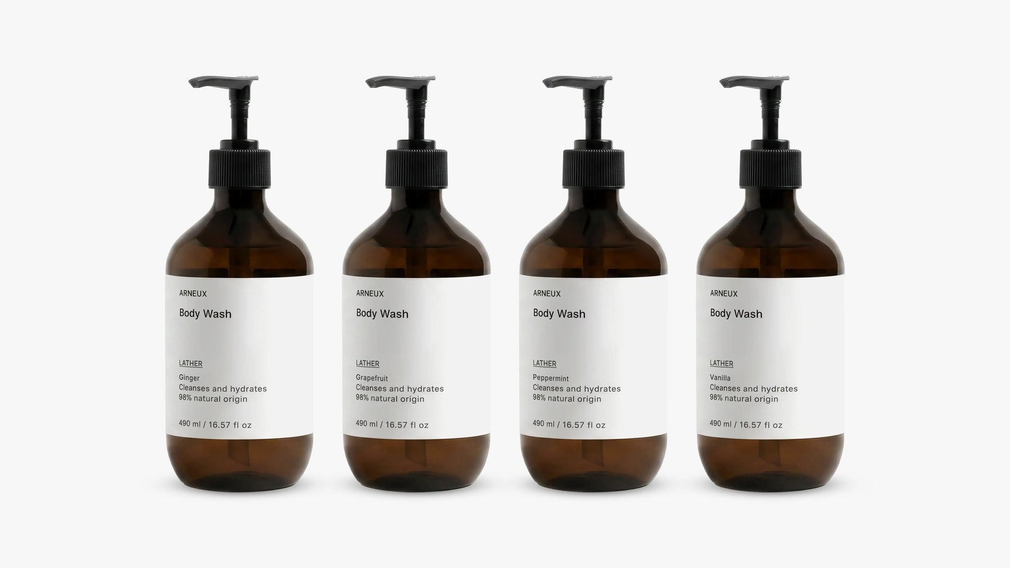 INDULGE The Shower Edit by ARNEUX, four organic body wash scents in amber bottles on white background