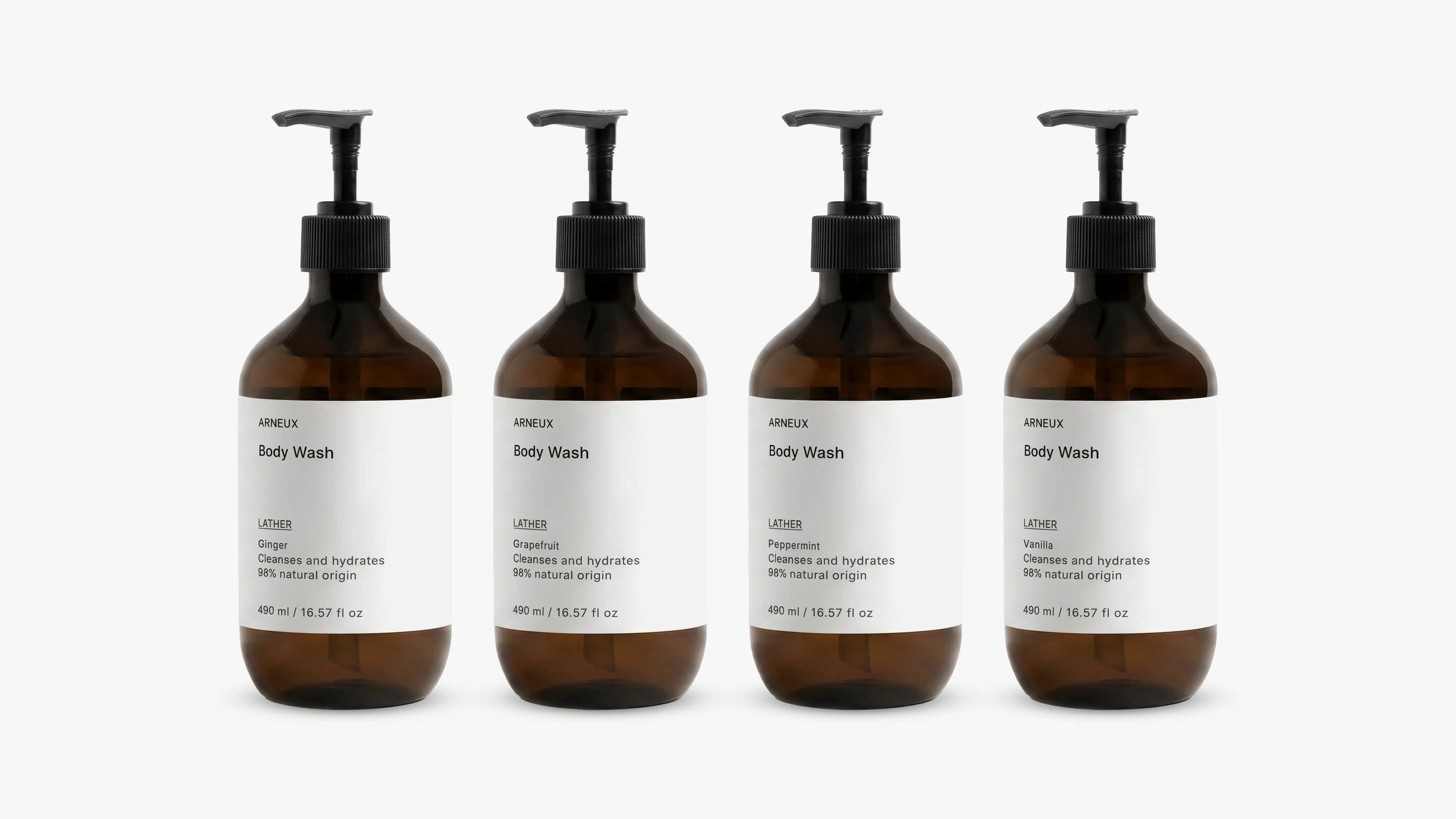 INDULGE The Shower Edit by ARNEUX, four organic body wash scents in amber bottles on white background