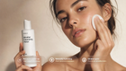 Woman pressing cotton pad to cheek using BARE micellar cleansing water, naturally dewy skin