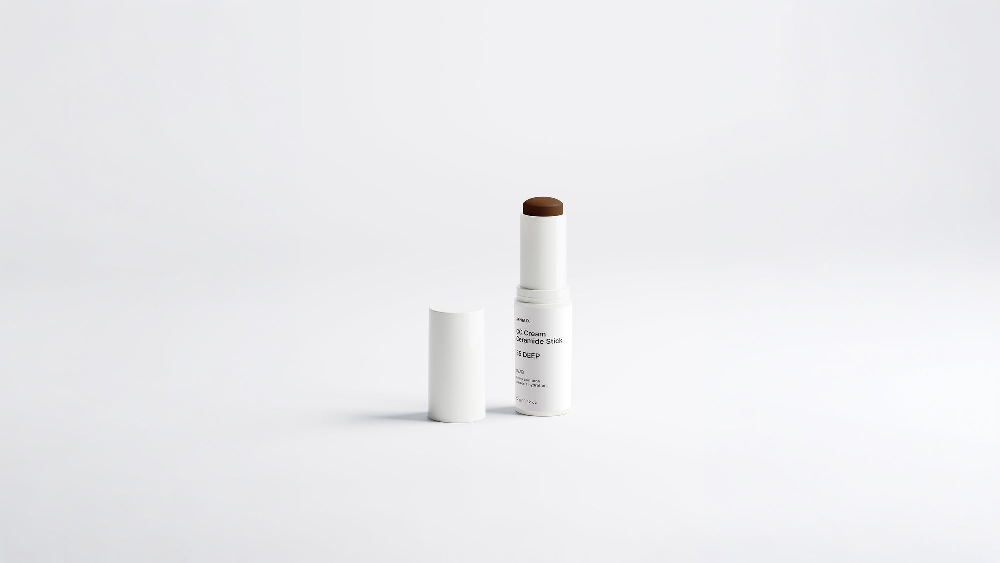 BLEND CC cream ceramide stick shade 35 Deep extended beside cap on white background