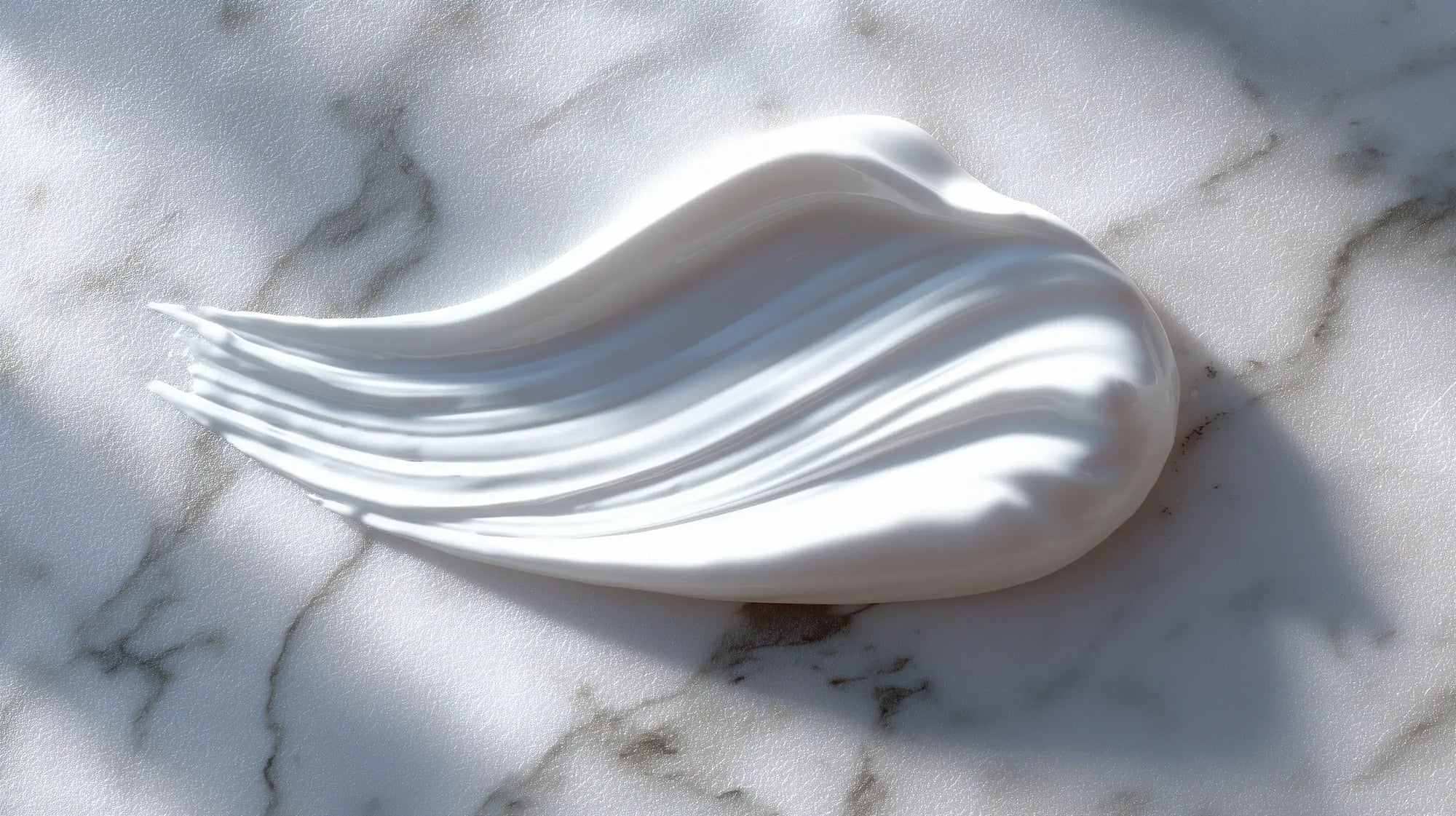 Lightweight blemish care moisturizer cream texture swatch on white marble, silky consistency