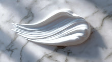 Lightweight blemish care moisturizer cream texture swatch on white marble, silky consistency