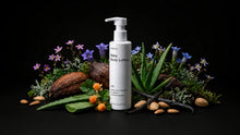CARE baby body lotion bottle with coconut, aloe vera, purple florals and almonds on black background