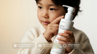 Young boy in cream sweater holding CARE baby body lotion, safe from birth allergen label free callouts