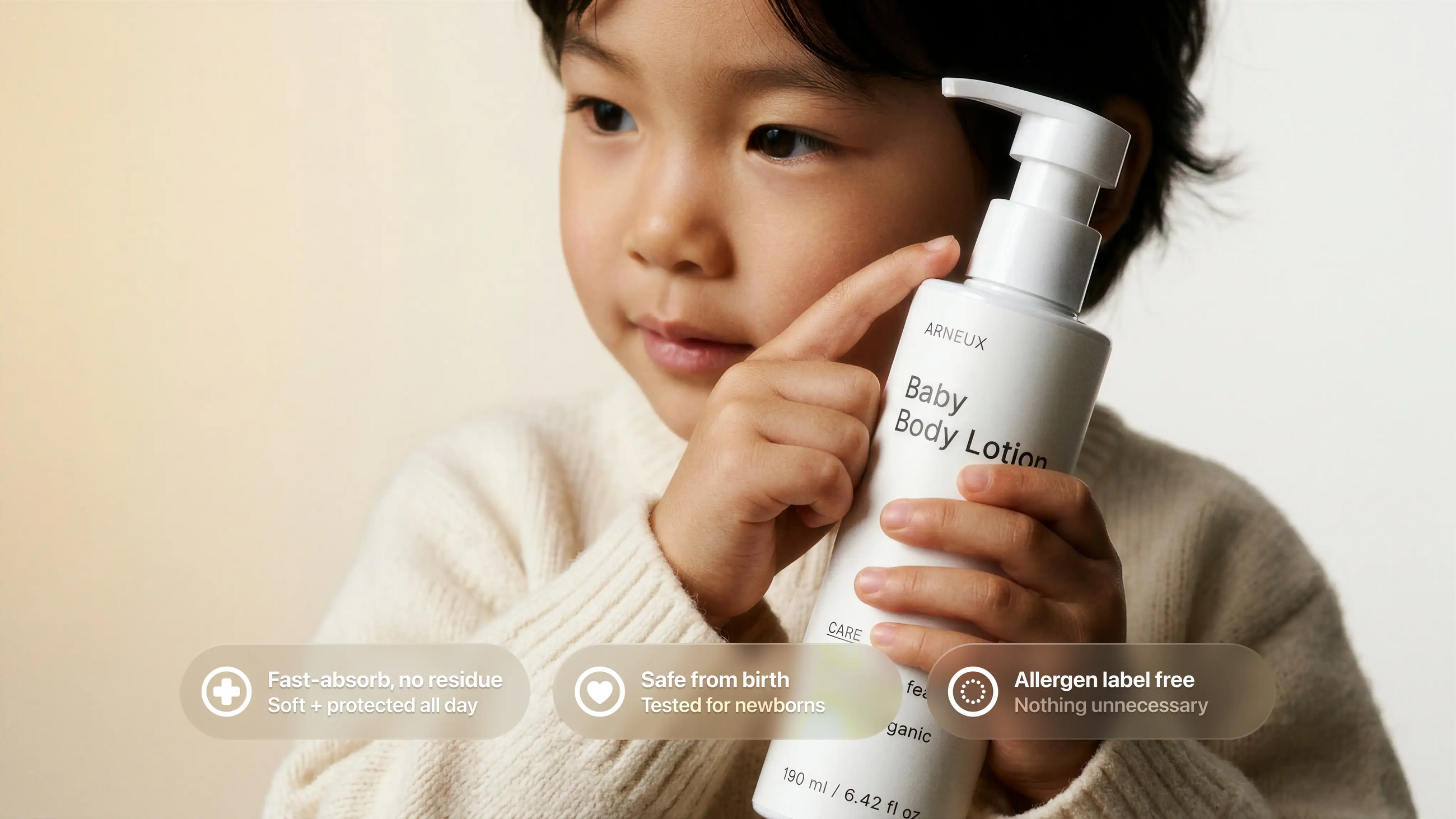 Young boy in cream sweater holding CARE baby body lotion, safe from birth allergen label free callouts
