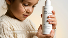 Young girl holding CARE baby body lotion, COSMOS Organic certified EU-made pediatrician approved callouts