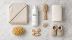 CLOUD foaming baby wash flatlay with hooded towel, hairbrush, washcloth and wooden baby toys on marble