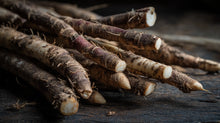 Burdock roots on dark wood surface close-up, skin-clearing botanical ingredient in DAY light cream