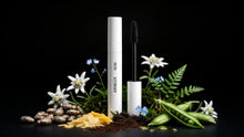 DEFINE mascara tube with edelweiss, blue flowers, ferns, pea pods and charcoal powder on black