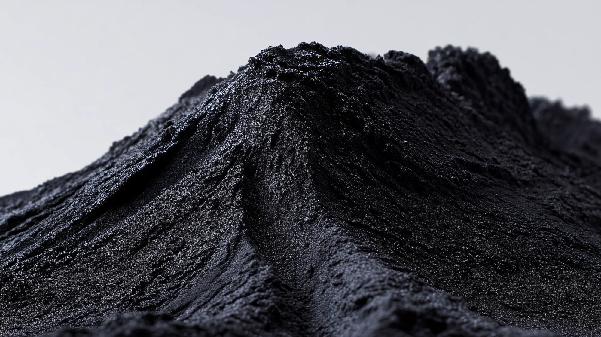Mound of fine black charcoal mineral powder, natural pigment ingredient in DEFINE mascara