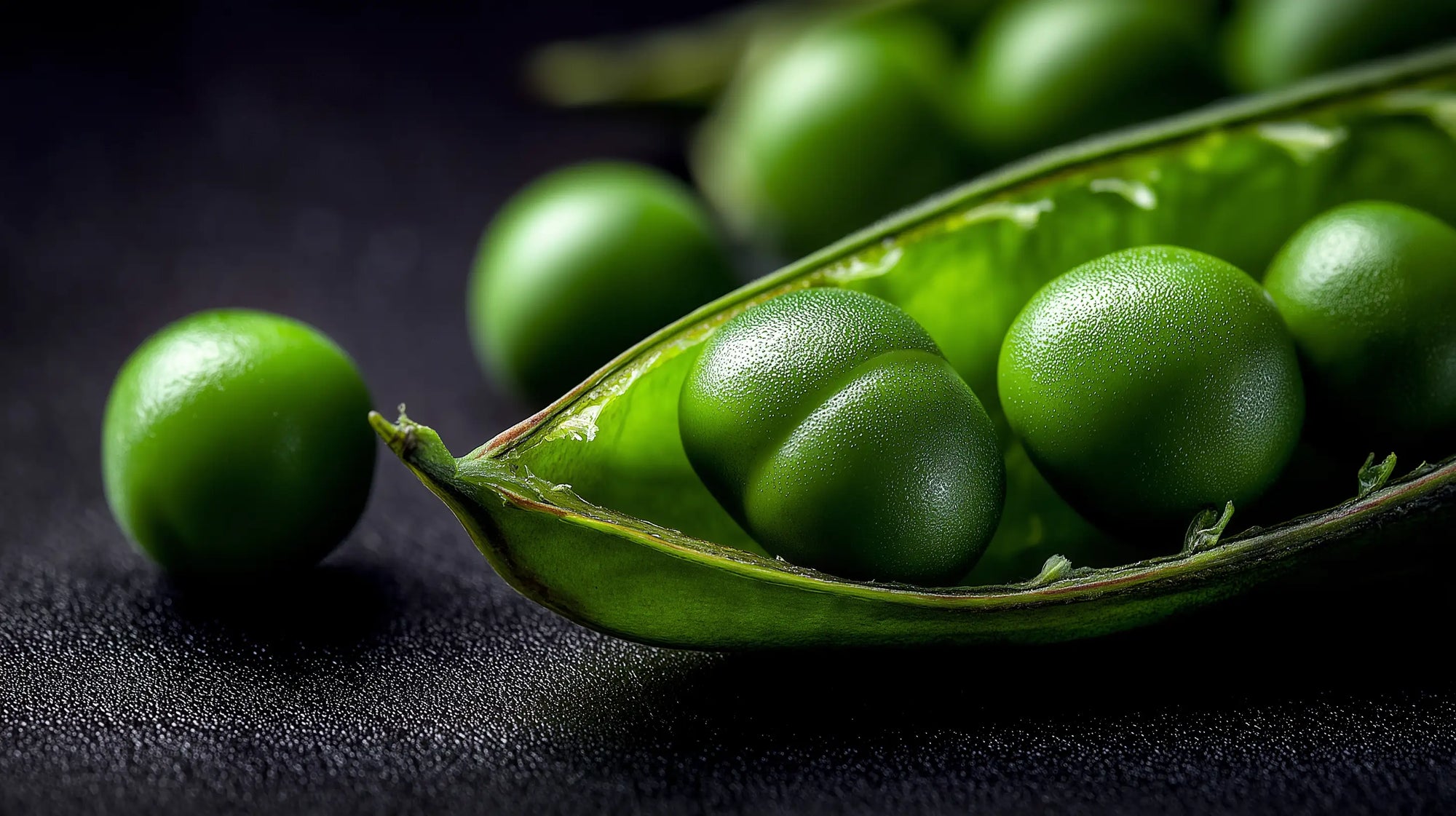 Fresh green pea pods split open close-up, source of strengthening pea peptide in DEFINE mascara