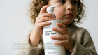 Young child with curly hair holding DELICATE baby wash, COSMOS Organic certified EU-made pediatrician approved