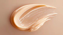Dark spot correcting cream peach-toned texture swatch on warm beige surface, smooth consistency