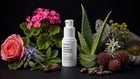 FOCUS eye serum bottle with pink geranium, rose, aloe vera, edelweiss and almonds on black background