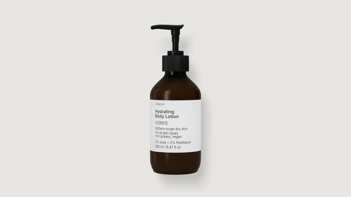 An amber glass pump bottle of ARNEUX hydrating body lotion with a black dispenser and a white label, centered on a light gray background
