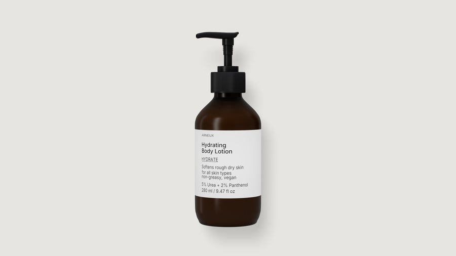 An amber glass pump bottle of ARNEUX hydrating body lotion with a black dispenser and a white label, centered on a light gray background