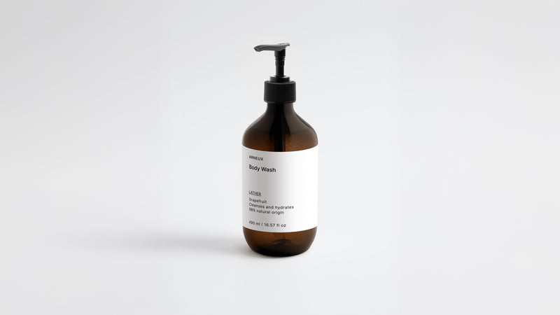 LATHER ginger body wash amber bottle, low three-quarter angle view on white background