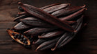 Dark vanilla bean pods close-up, warm aromatic ingredient in LATHER vanilla body wash