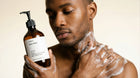 Man lathering LATHER ginger body wash on chest in shower, rich foaming clean rinse