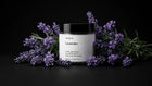 LAVENDER travel candle surrounded by fresh purple lavender sprigs on black background