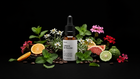 LIFT caffeine booster bottle with mint, geranium, orange, kaffir lime and coffee beans on black