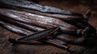 Dark vanilla bean pods close-up, conditioning botanical ingredient in MATTE lipstick