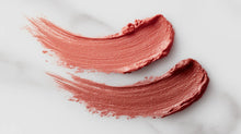 Dusty rose matte lipstick color swatch smeared on white marble showing pigment and texture