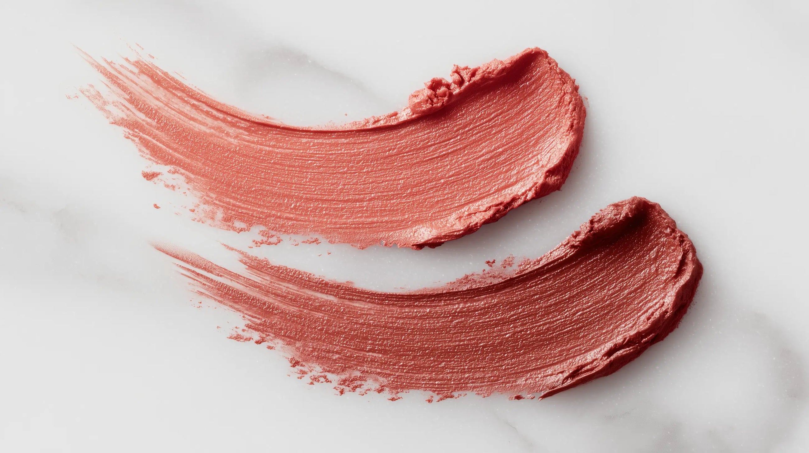 Dusty rose matte lipstick color swatch smeared on white marble showing pigment and texture