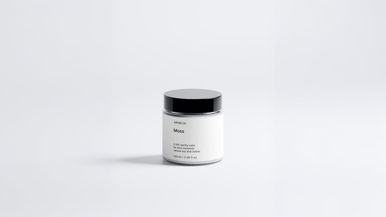 Arneux MOSS travel candle glass jar with black lid, fresh green woody soy wax candle front view on grey background