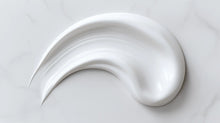 Rich nourishing night cream thick texture swatch on white marble, dense buttery consistency