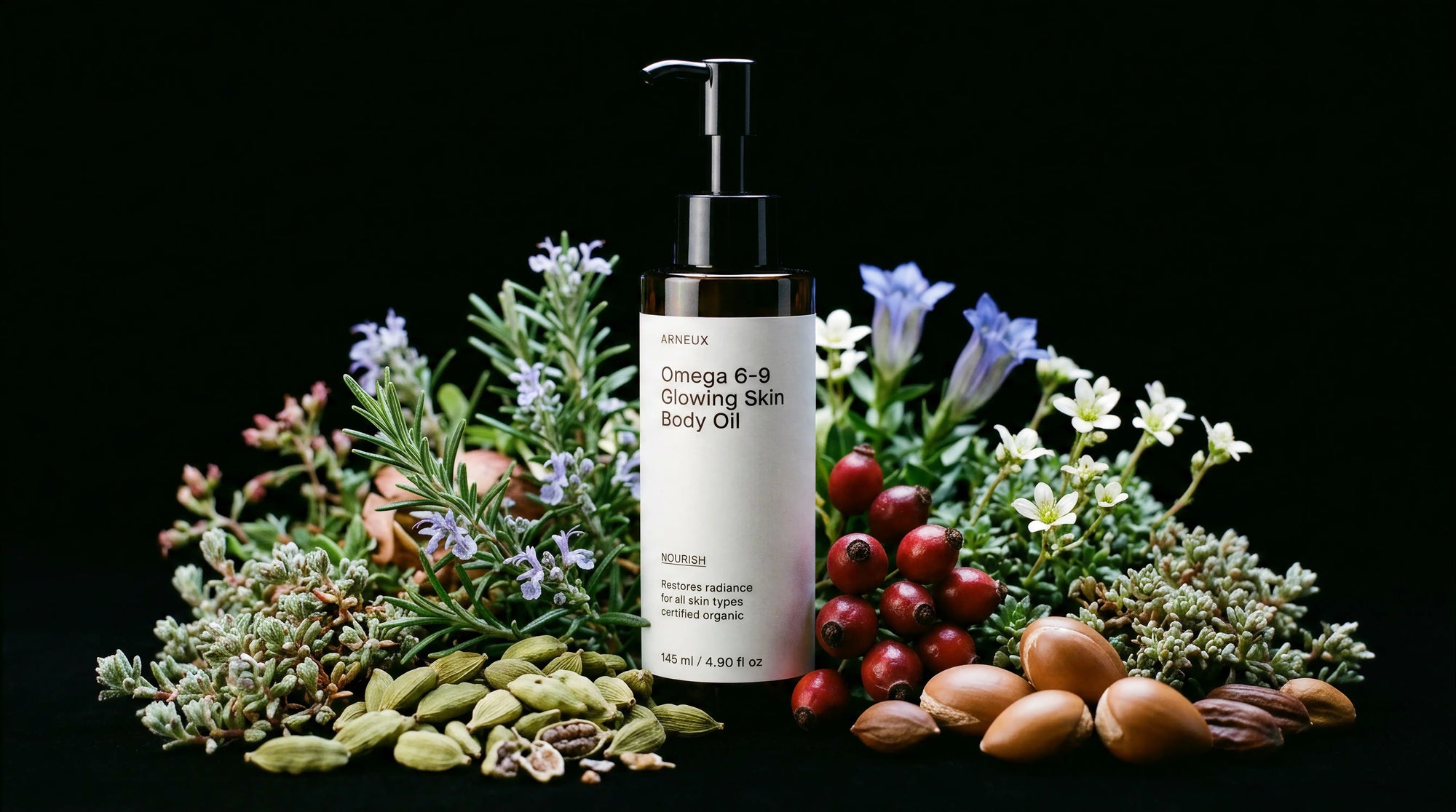 NOURISH body oil bottle surrounded by rosemary, blue florals, rosehips and cardamom on black background