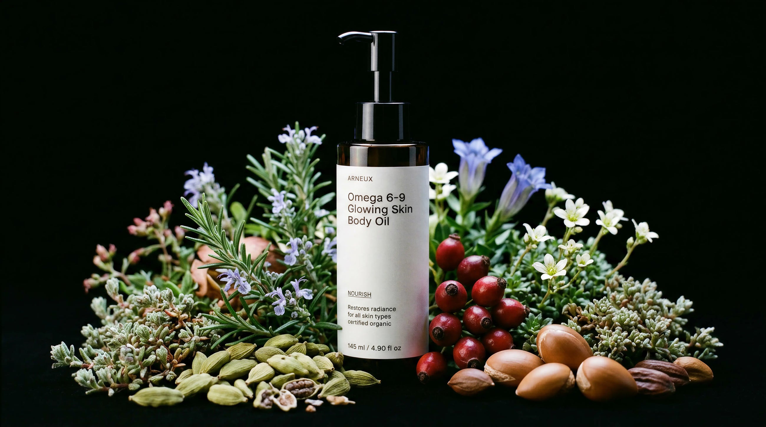 NOURISH body oil bottle surrounded by rosemary, blue florals, rosehips and cardamom on black background