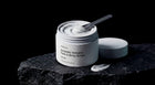 REFINE icelandic volcano scrub jar open on dark volcanic rock with spatula, product texture visible