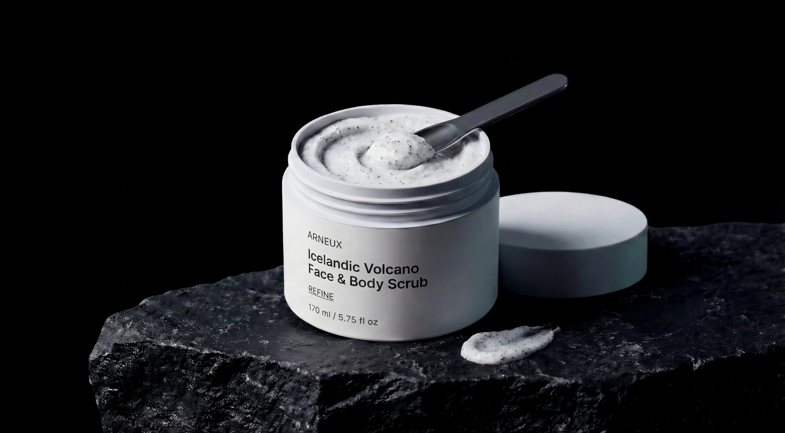 REFINE icelandic volcano scrub jar open on dark volcanic rock with spatula, product texture visible