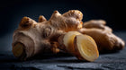 Sliced fresh ginger root on dark surface, anti-inflammatory botanical in REFRESH face mist
