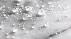 Fine prebiotic face mist droplets scattered on marble surface, weightless hyaluronic mist texture