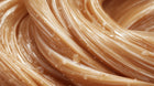 Golden hair strands close-up showing smooth repaired texture after keratin intensive hair mask