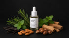 ROOT hair oil bottle with rosemary, mint, vanilla pods, almonds and sandalwood on black background