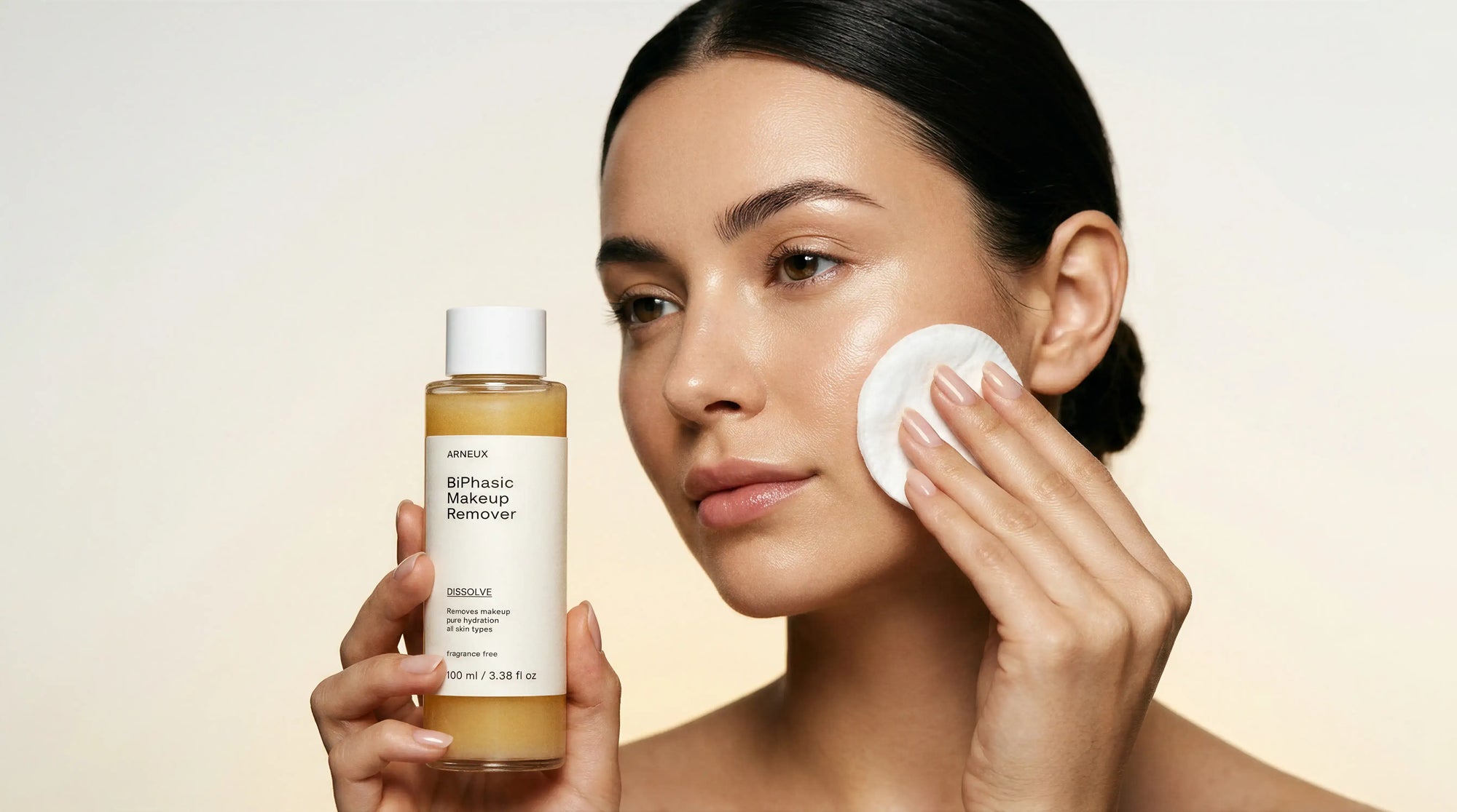Woman using cotton pad with Arneux DISSOLVE biphasic makeup remover, 9PM evening double cleanse skincare routine