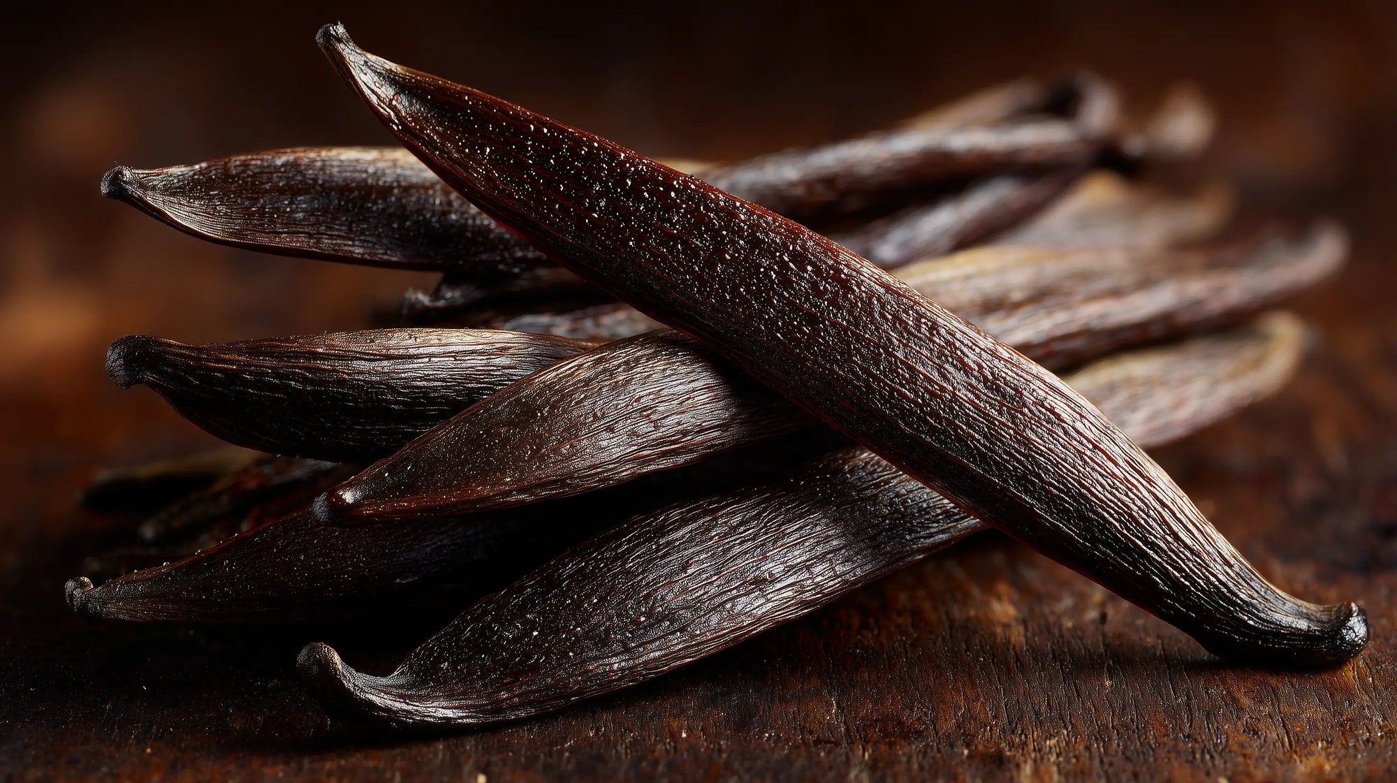 Dark vanilla pods on rustic wooden surface close-up, natural scent ingredient in SOFT gentle baby shampoo