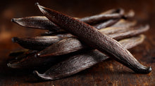 Dark vanilla pods on rustic wooden surface close-up, natural scent ingredient in SOFT gentle baby shampoo