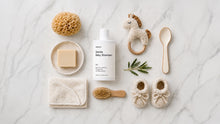 SOFT gentle baby shampoo flatlay with natural sponge, soap bar, wooden brush and baby booties on marble