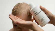 Adult hands washing newborn's fine hair with SOFT gentle baby shampoo, tear-free safe from birth